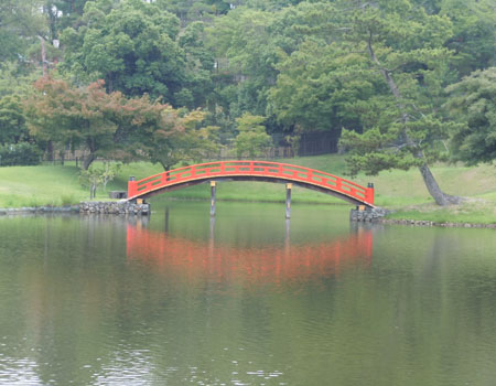 緑の庭園に鮮やかな朱色が映える
